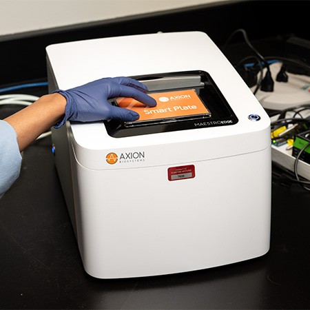 A hand placing a plate into an Axion Maestro Edge