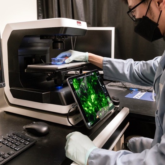 A researcher at the Echo Revolve microscope with its tablet display