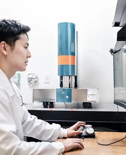 A researcher at the controls of the Miltenyi UltraMicroscope Blaze light-sheet microscope