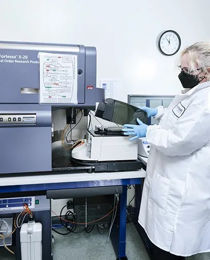 A staff member loading a plate on the LSRFortessa X-20